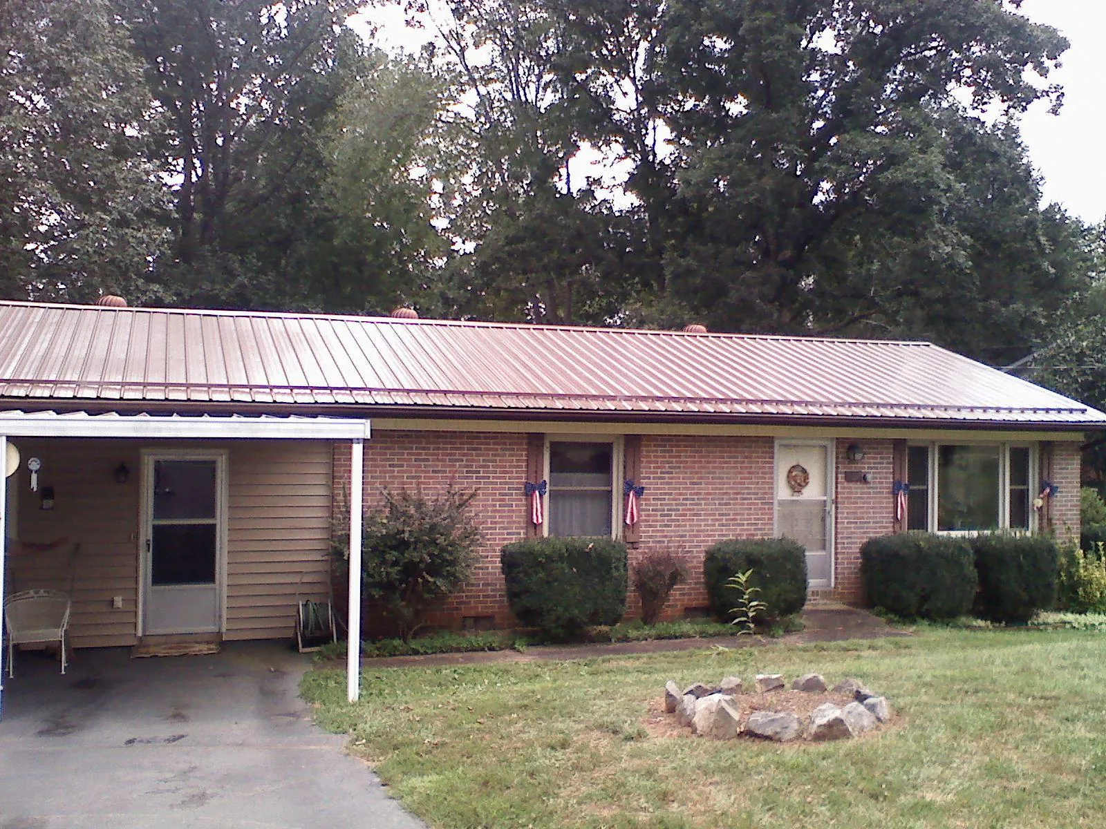 Bronze metal roof and carport on a brick ranch home — Roof Repair work by our crew in Snow Hill